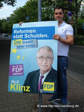 Daniel Wilkening beim Aufhängen von FDP-Wahlplakaten in Gravenbruch.